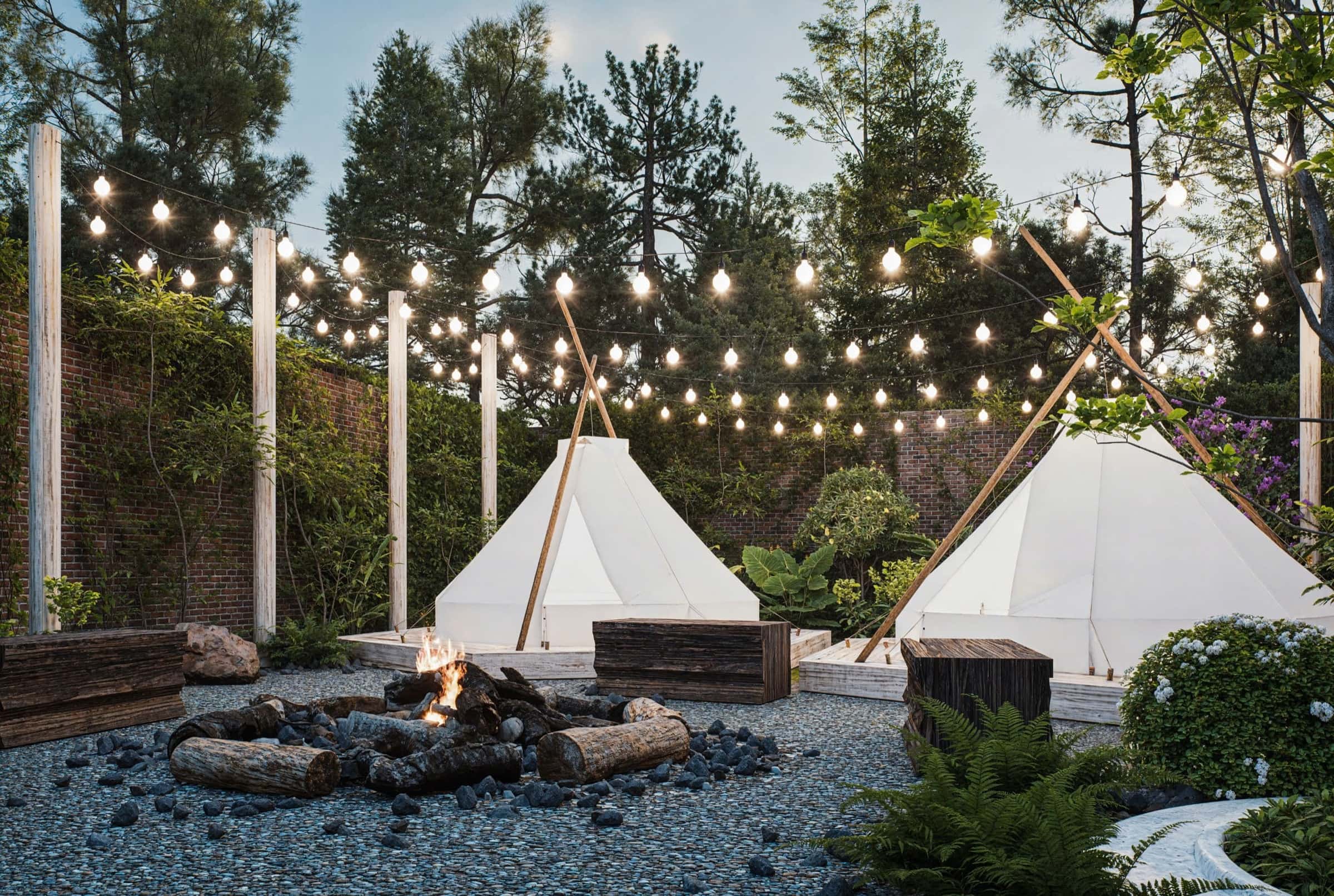 Khu lều glamping với dây đèn và lửa trại giữa vườn cây tại Cuchi Downtown