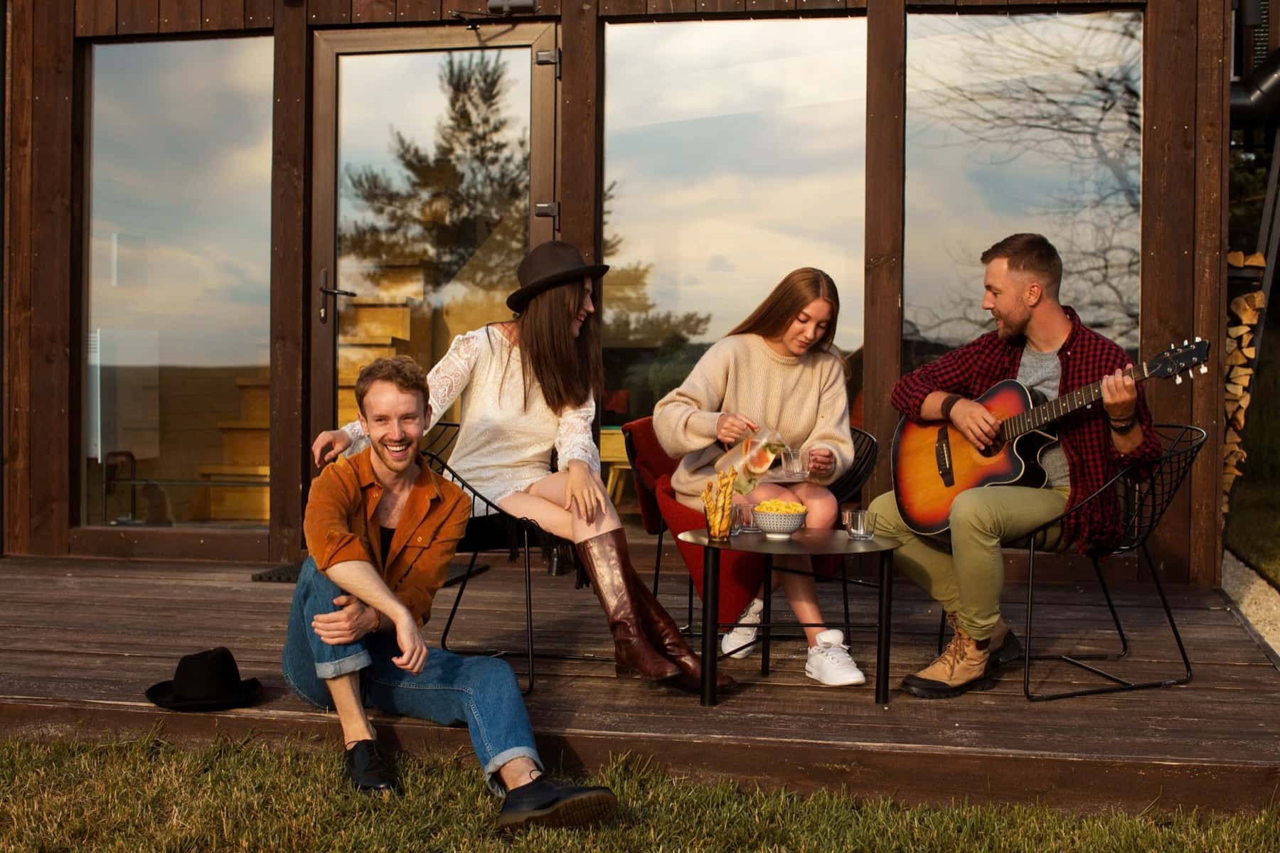 Friends playing guitar on the wooden porch